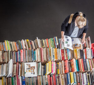 person looking through several book from bird's eye view