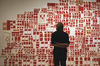 A woman looks at a graphic red and white wall painting