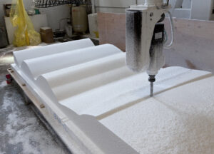 A drill is positioned atop an undulating white panel