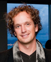 A smiling man wearing a scarf